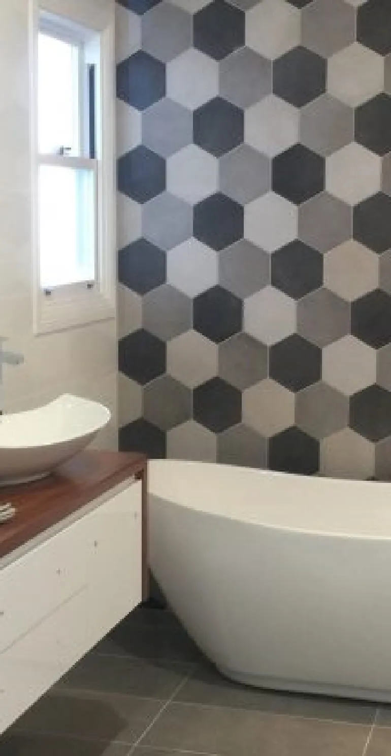 Bathroom at Morpeth with hexagon feature wall and freestanding bath
