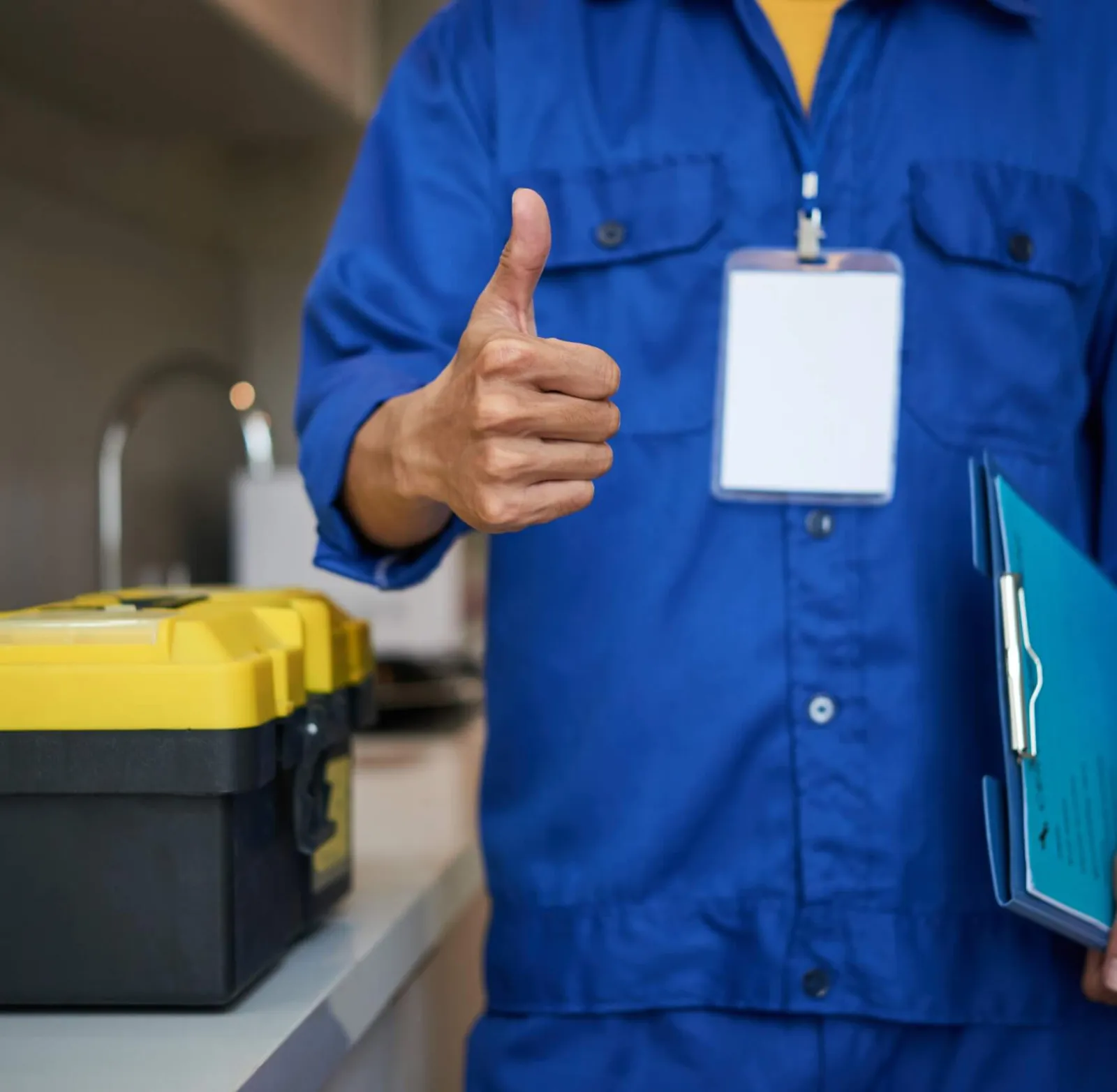 Plumber giving a thumbs up beside a kitchen sink