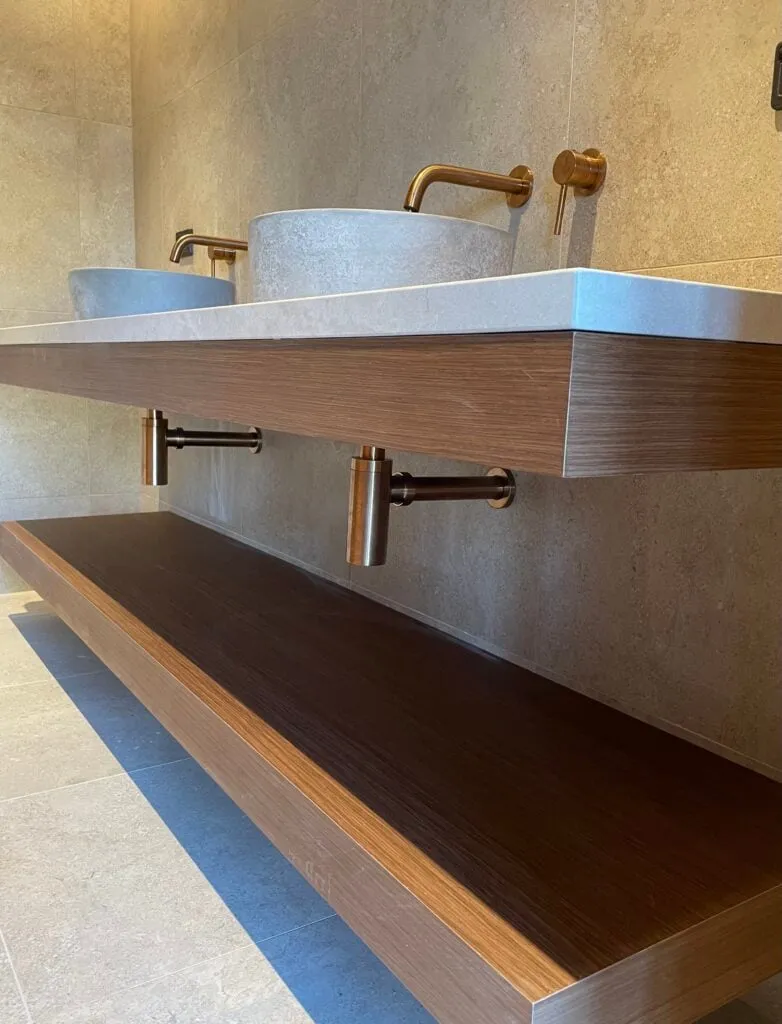 Twin stone basins with brass tapware on a floating timber vanity, Pokolbin